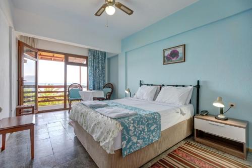 a bedroom with a large bed and a balcony at Assos Terrace Hotel in Behramkale