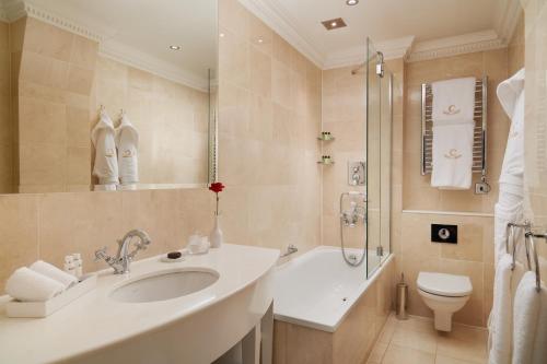 a bathroom with a sink and a toilet and a shower at The Chesterfield Mayfair in London