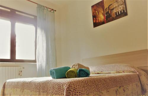 a bedroom with a bed with towels and a window at B&B Roma Nord 311 in Rome