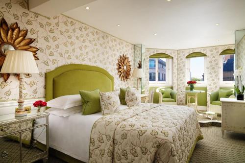 a bedroom with a large bed with a green headboard at The Chesterfield Mayfair in London