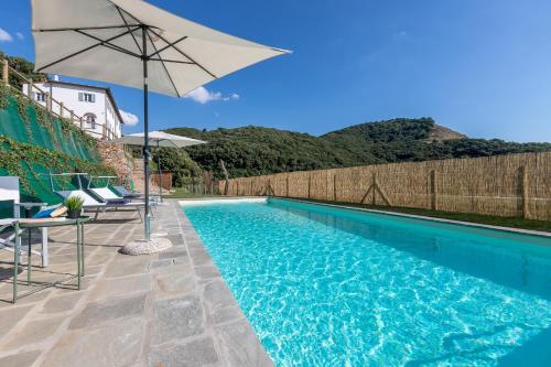 a swimming pool with an umbrella and chairs and a table and an umbrella at B&B Pietra a Padule in Filettole