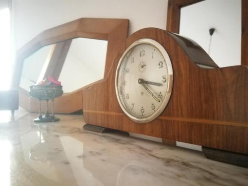 a wooden clock sitting on the floor next to a window at Carru de ammentos in Ozieri
