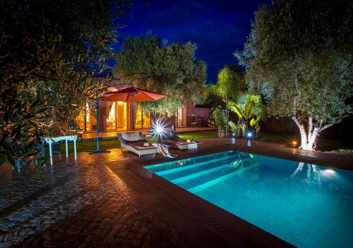 a swimming pool in a backyard at night at VILLA PASCHMINA PISCINE CHAUFFEE in Ourika