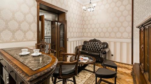 a living room with a table and a chair and a desk at Exclusive Royal Apartments in Krakow