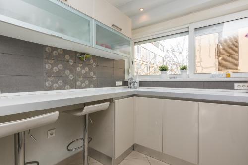 uma cozinha com armários brancos e uma janela em Barita em Zadar