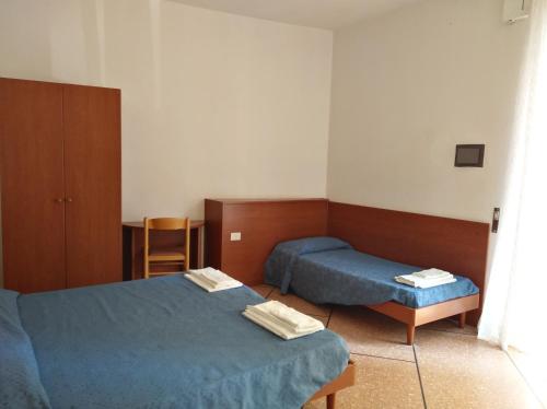 Habitación de hotel con 2 camas y mesa en Hotel Suisse, en Sestri Levante