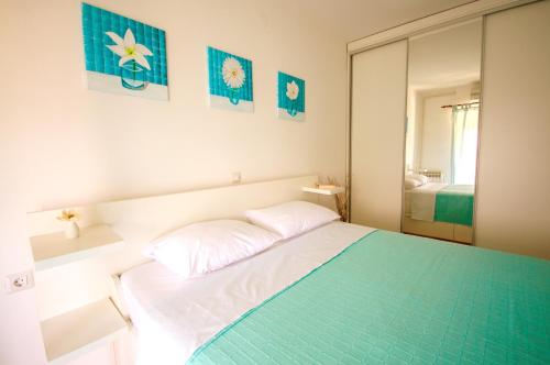 a small bedroom with a bed and a mirror at Apartment Ivis in Vinkuran