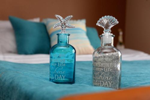 two bottles sitting on top of a bed at Villa Komitata-Pool and Jacuzzi in Balchik
