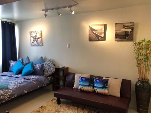 a living room with a couch and pillows at Centropolis in Manila