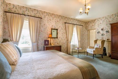 a bedroom with a large bed and a chair at Carrig Country House & Restaurant in Killorglin