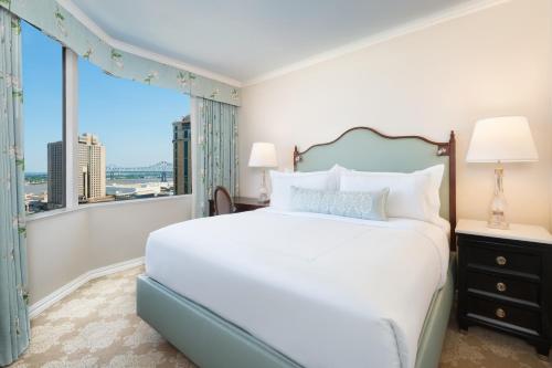 1 dormitorio con cama grande y ventana grande en The Windsor Court en Nueva Orleans