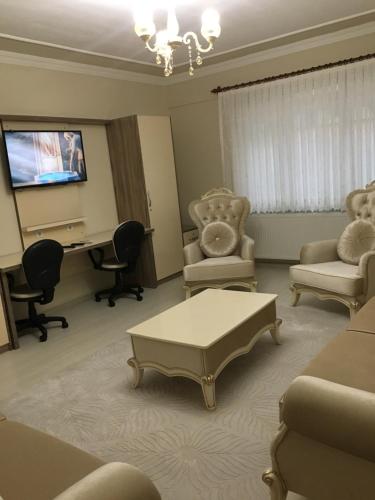 sala de estar con sofá, sillas y escritorio en YALI Apart Hotel en Trebisonda