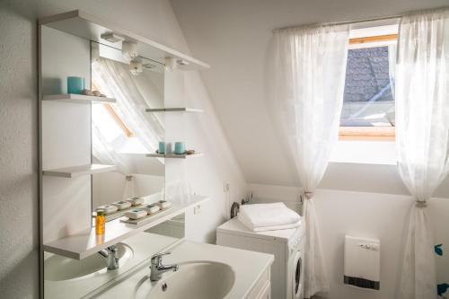 La salle de bains est pourvue d'un lavabo, de toilettes et d'une fenêtre. dans l'établissement Gîtes & Chambes d'Hôtes Fugler, à Orschwihr