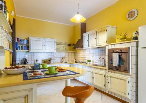 マリーナ・ディ・マンカヴェルサにあるDimora Smeraldoの黄色の壁と白いキャビネットが備わる広いキッチン