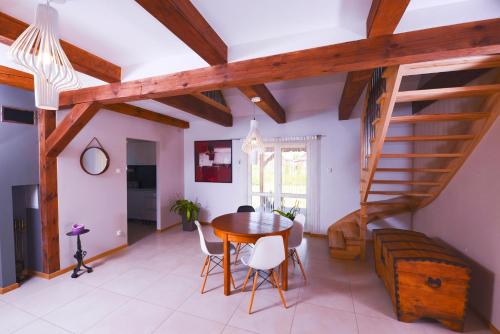 une salle à manger avec une table et un escalier dans l'établissement Apartament Topczewo, à Topczewo