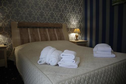 a bed with white towels on top of it at Garden Hall in Ternopilʼ