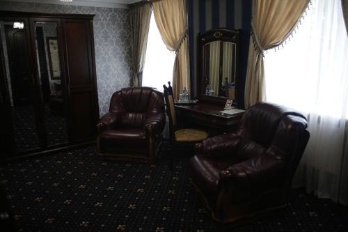 a room with two chairs and a desk and a mirror at Garden Hall in Ternopilʼ