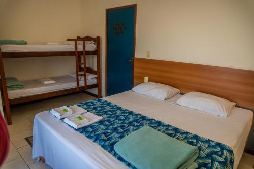 a bedroom with a bed with towels on it at Pousada Piquara in Mangaratiba