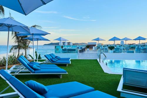 a row of blue lounge chairs next to a swimming pool at Eurostars Ibiza in Ibiza Town
