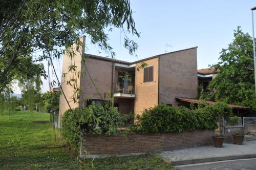 a house with a brick wall in front of it at La villetta d' angolo in Migliarino