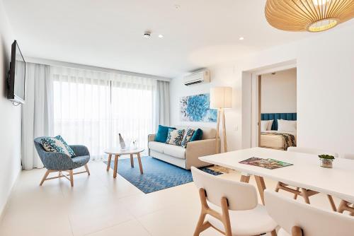 a living room with a table and a dining room at Eurostars Ibiza in Ibiza Town
