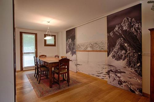 a dining room with a table and a painting on the wall at ALTIDO Superb Apartments for 6 with Mountain View and Garden in Courmayeur in Courmayeur