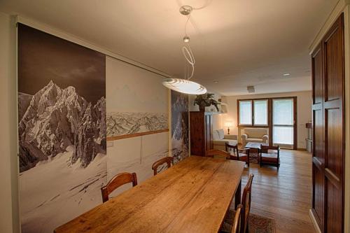 a dining room with a large wooden table and chairs at ALTIDO Superb Apartments for 6 with Mountain View and Garden in Courmayeur in Courmayeur