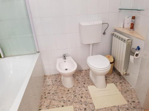 a white bathroom with a toilet and a sink at Santino Apartment in Sibiu