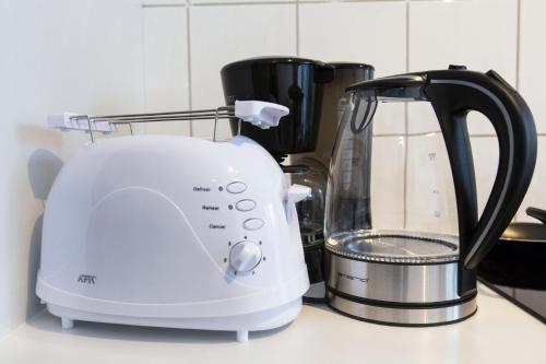 a white toaster sitting on top of a kitchen counter at AVR Apartment Geestemunde in Bremerhaven