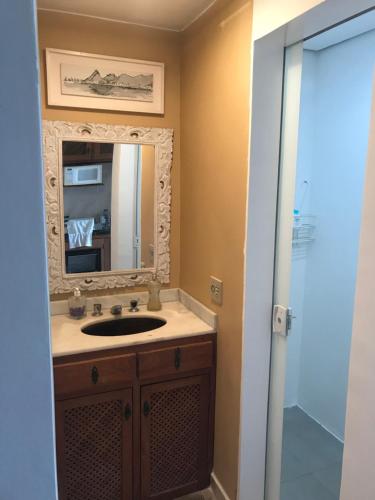 a bathroom with a sink and a mirror at Apartamento Duplex Angra Inn in Angra dos Reis