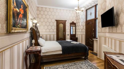 una camera d'albergo con letto e TV di Exclusive Royal Apartments a Cracovia