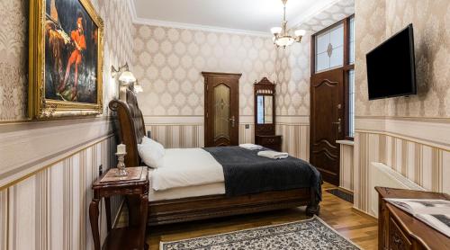 a hotel room with a bed and a television at Exclusive Royal Apartments in Kraków