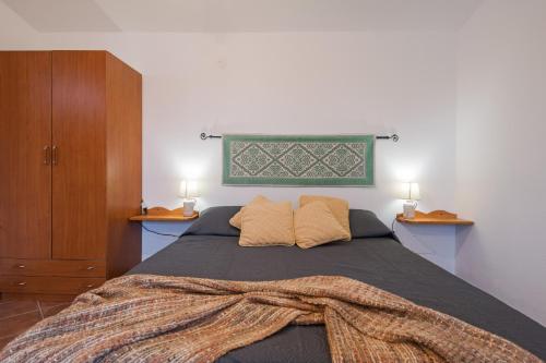 a bedroom with a bed with a blanket on it at S'Ulumu in Dorgali