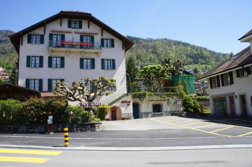 a large white building on the side of a street at Hotel de Bahyse in Blonay