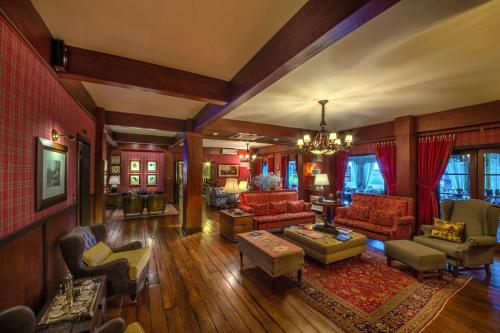 a living room filled with furniture and a chandelier at Hotel Casa da Montanha in Gramado