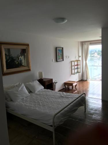 a bedroom with a bed and a large window at Apartamento Duplex Angra Inn in Angra dos Reis