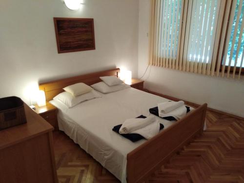 sypialnia z dużym łóżkiem z białą pościelą i poduszkami w obiekcie Stelius I w mieście Pomorie