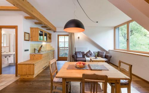 eine Küche und ein Wohnzimmer mit einem Holztisch in der Unterkunft Naturresidenz Mair Zu Hof in Sand in Taufers