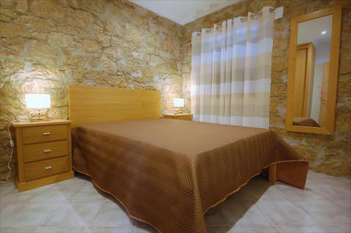 um quarto com uma cama e uma parede de pedra em Vila Baltum - Free private parking - Wifi - Airco # by bedzy # em Albufeira