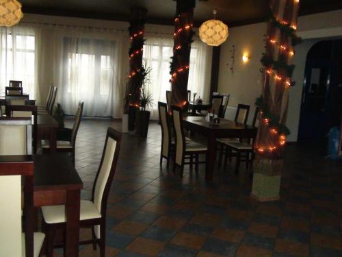 a dining room with a table and chairs and lights at Hotel Europa in Polanica-Zdrój