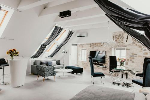 Coco Chanel Boutique Apartment في برنو: غرفة معيشة بأثاث اسود وبيض