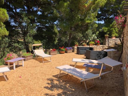 a group of picnic tables and chairs in a yard at Villa Mariza in Scopello