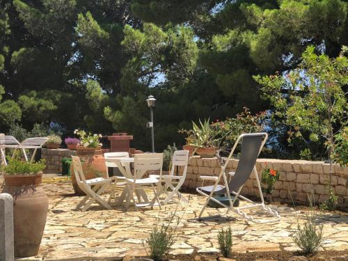 a group of chairs and tables in a garden at Villa Mariza in Scopello