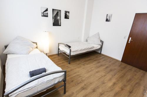 a room with two beds and a chair in it at AVR Apartment HOF 1 in Bremerhaven