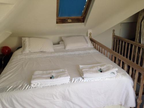 ein weißes Bett mit Handtüchern darüber in der Unterkunft Gabe's Rooms in Central London in London