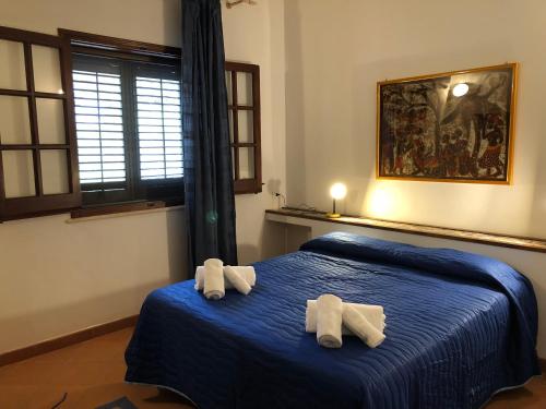 a bedroom with two towels on a blue bed at Villa Mariza in Scopello