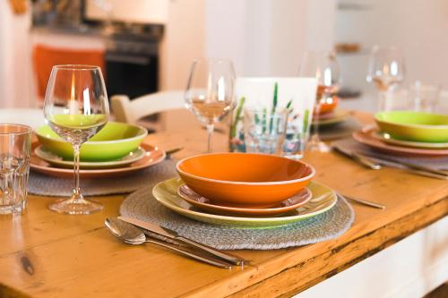 a wooden table with plates and glasses of wine at La Casetta in Calimera
