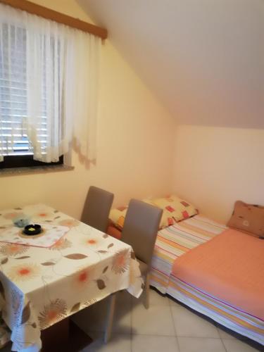 a dining room with two beds and a table at Apartment Bonita in Vir