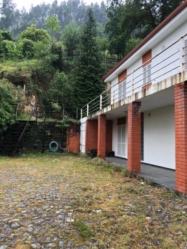 - un bâtiment avec un balcon et une cour dans l'établissement Casa do Geres ( Rio Caldo / S.Bento ), à Gerês