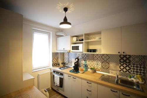 a kitchen with white cabinets and a sink and a window at SMP apartment 3 in Timişoara
